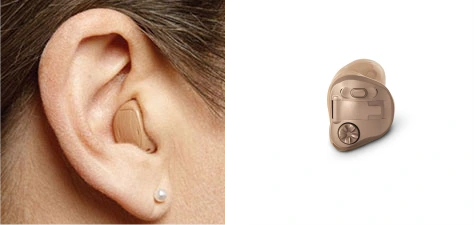 Małe douszne aparaty słuchowe typu ITE, delikatnie wystające w ucha z łącznością bezprzewodową bluetooth.